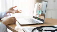 
  Person sitting at a desk while talking to a healthcare professional on the computer
