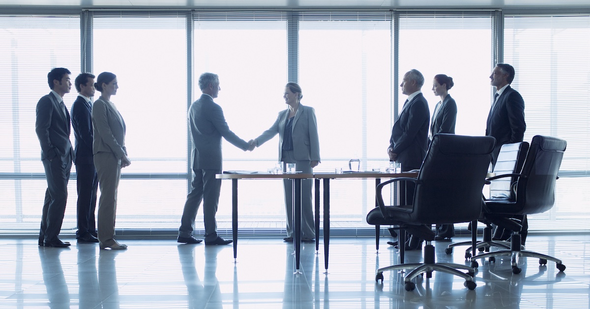 Business professionals shake hands to formalise a deal Business professionals shake hands to formalise a deal