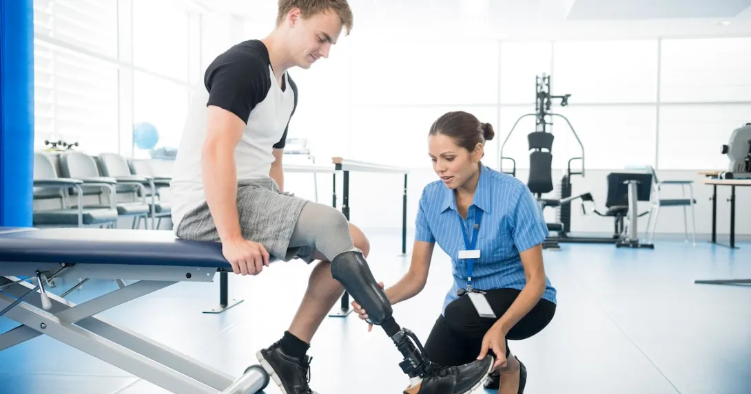 Person with an amputated limb working with a physical therapist Person with an amputated limb working with a physical therapist