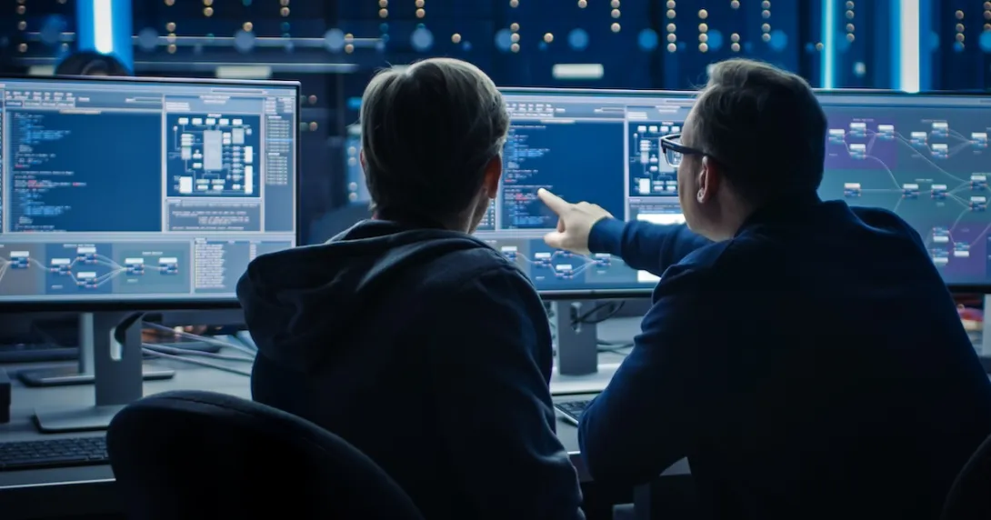 Two people sitting in front of two computer monitors looking at data on the screens
Two people sitting in front of two computer monitors looking at data on the screens